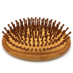 Oval bamboo hair brush with bamboo pins and cushioned base on a white background