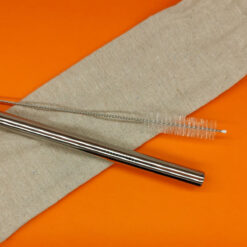 Stainless steel boba straw with cleaning brush and cotton pouch on an orange background