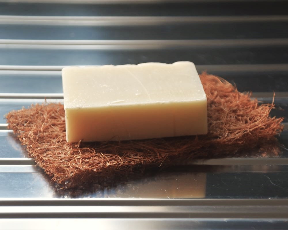 Image of a Uno Dishwashing Soap bar on a Safix pad, on a kitchen counter.
