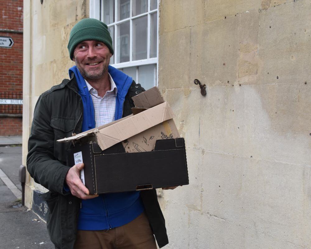 Image of a man carrying two boxes 