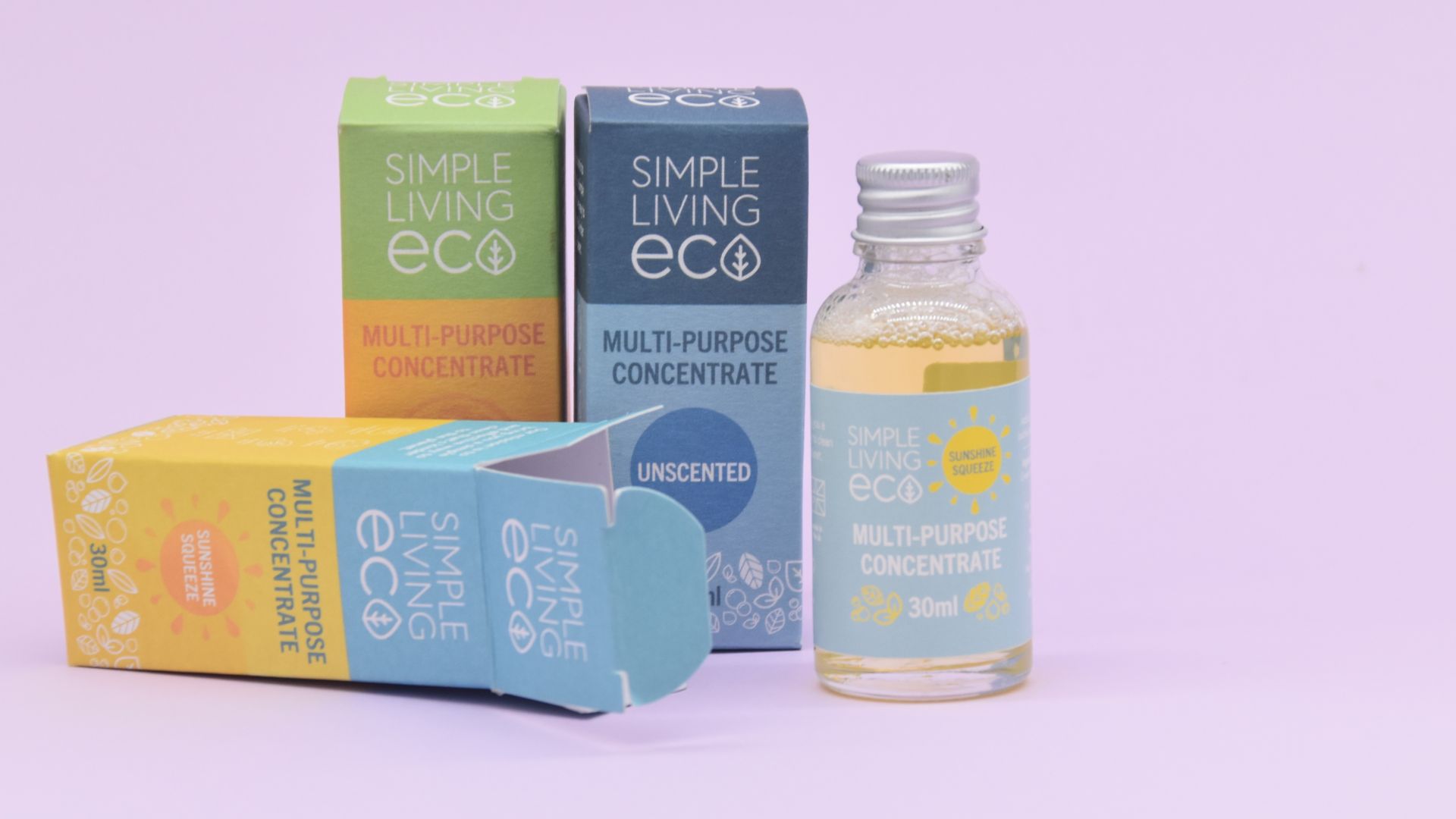 Image of multi purpose cleaning concentrate, two standing boxes and one bottle, with an opened box laying to the right hand front. against a lilac background.