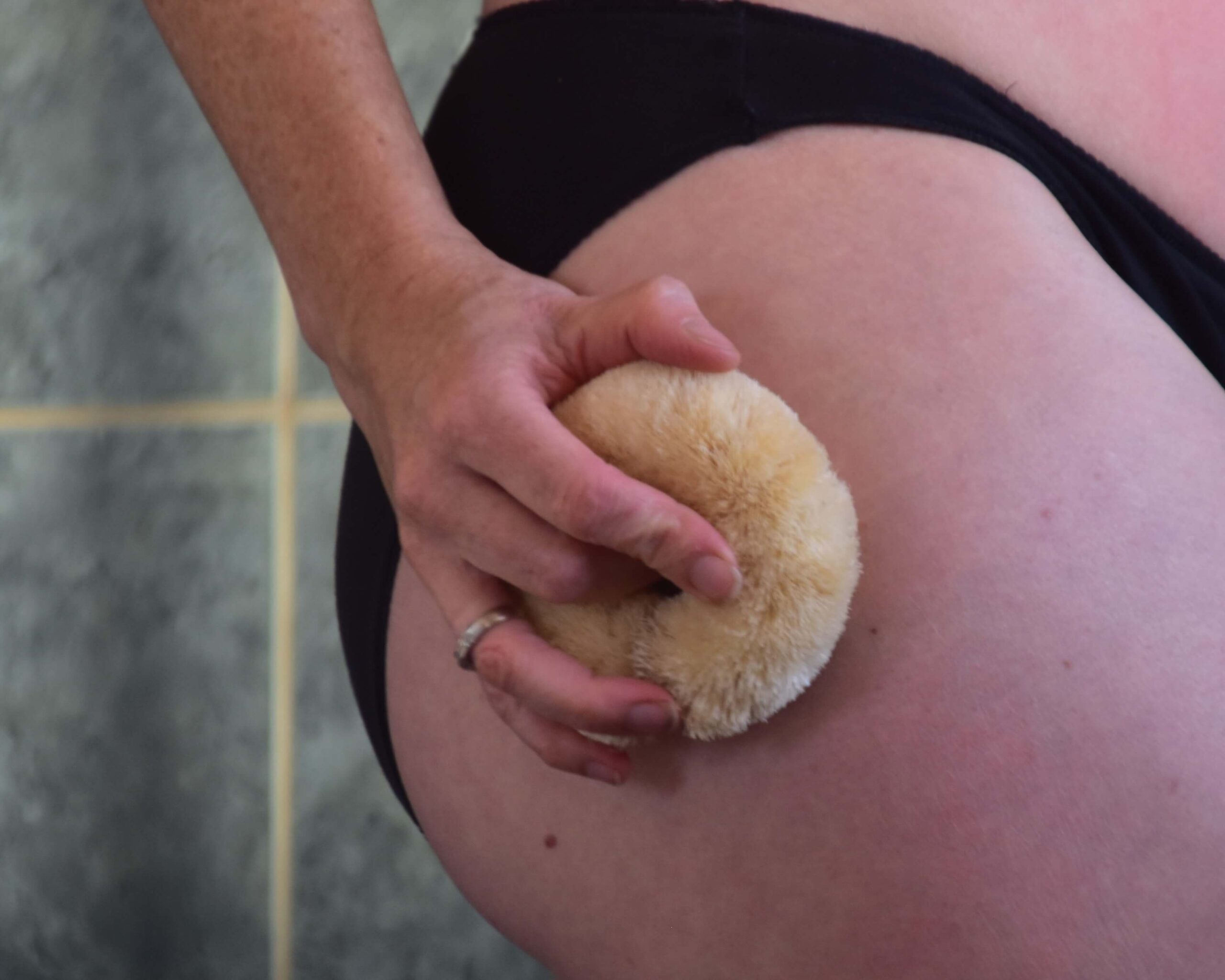 Image of a sisal body brush dry brushing an upper thigh