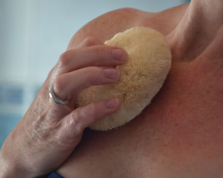 Image of a sisal body brush being used on a collar bone
